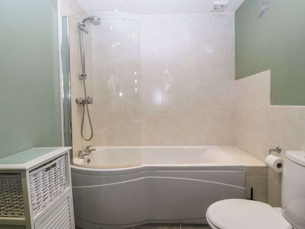 A bathroom with a bathtub and a shower at No 1 The Granary in Capel Coch near Llannerch-Y-Medd