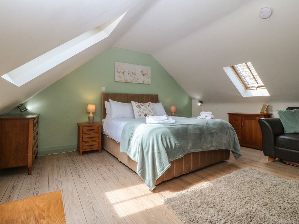 A bedroom with a bed and a dresser at No 1 The Granary in Capel Coch near Llannerch-Y-Medd