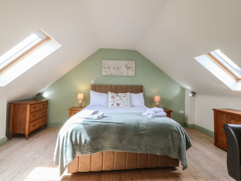 A bedroom with a bed and bedside tables at No 1 The Granary in Capel Coch near Llannerch-Y-Medd