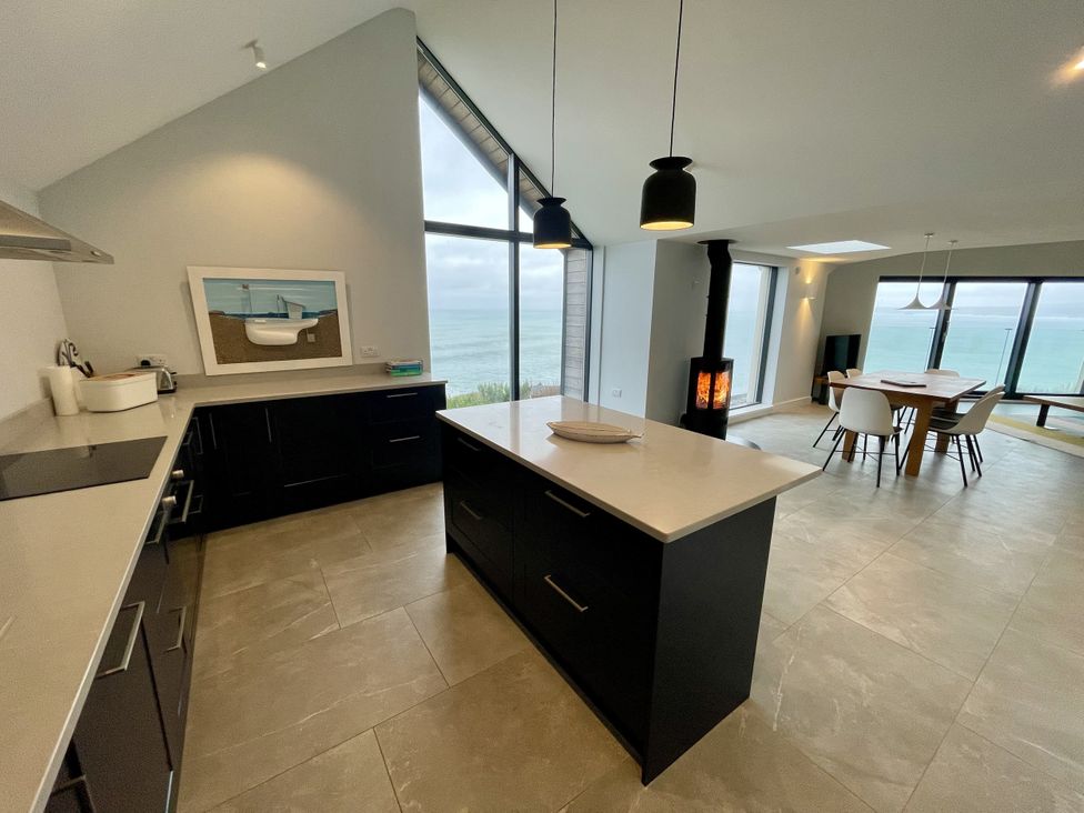 A kitchen with a view of the sea and a dining area at The Old Coastguard Lookout Port Isaac