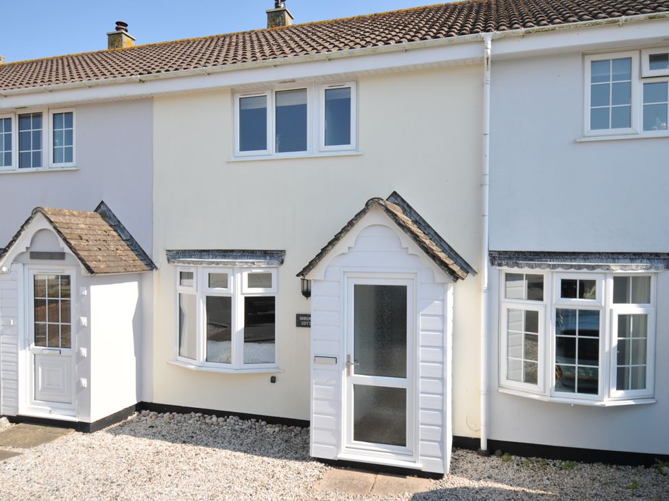 An exterior view of a house with a white door and windows at Shrimper's Cottage Tredrizzick near St Minver