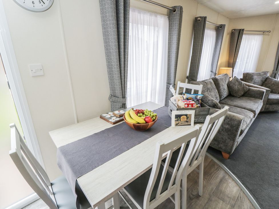 A dining area with a table and fruit at The Cotswold Holiday Lodge in Evesham