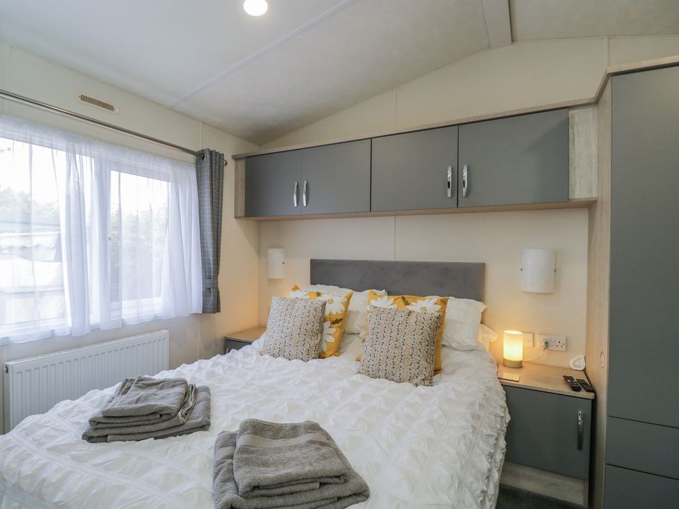 A bedroom with a bed and cabinets at The Cotswold Holiday Lodge Evesham