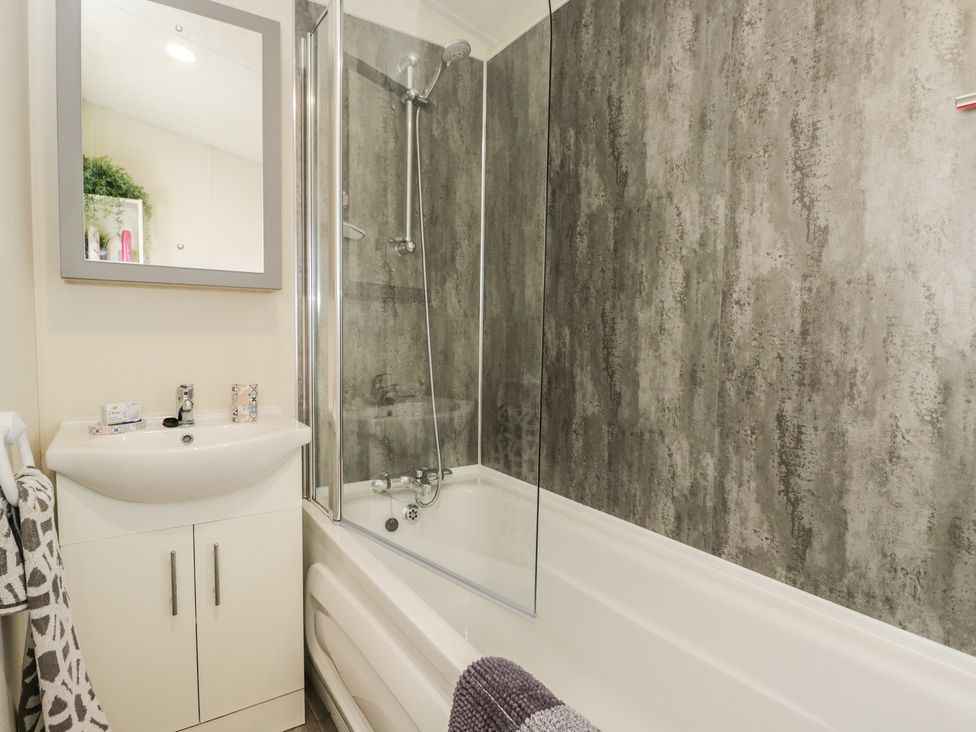 A bathroom with a bathtub and shower at The Cotswold Holiday Lodge in Evesham