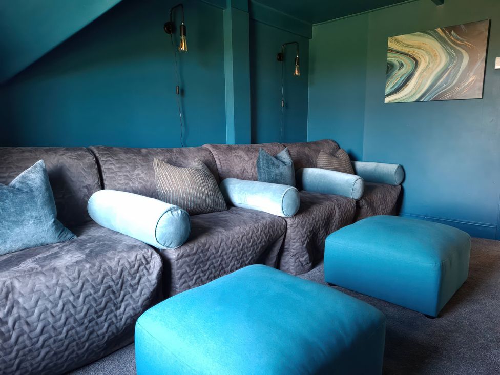A living room with a sofa and cushions at Teifi Villa in St Dogmaels
