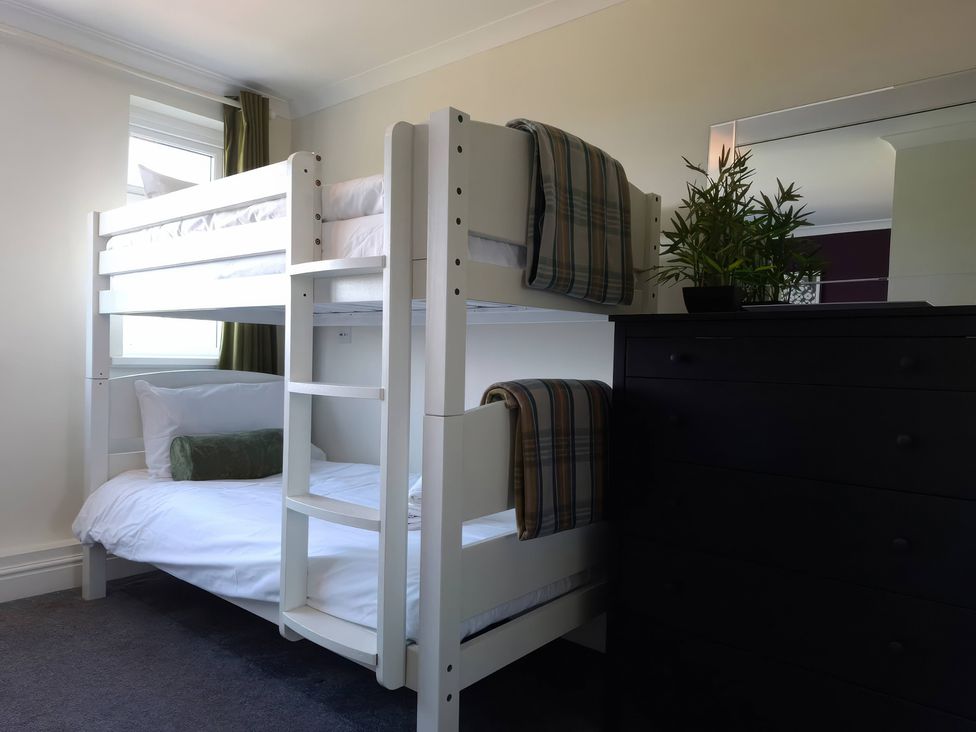 A bedroom with a bunk bed and a dressing table at Teifi Villa St Dogmaels