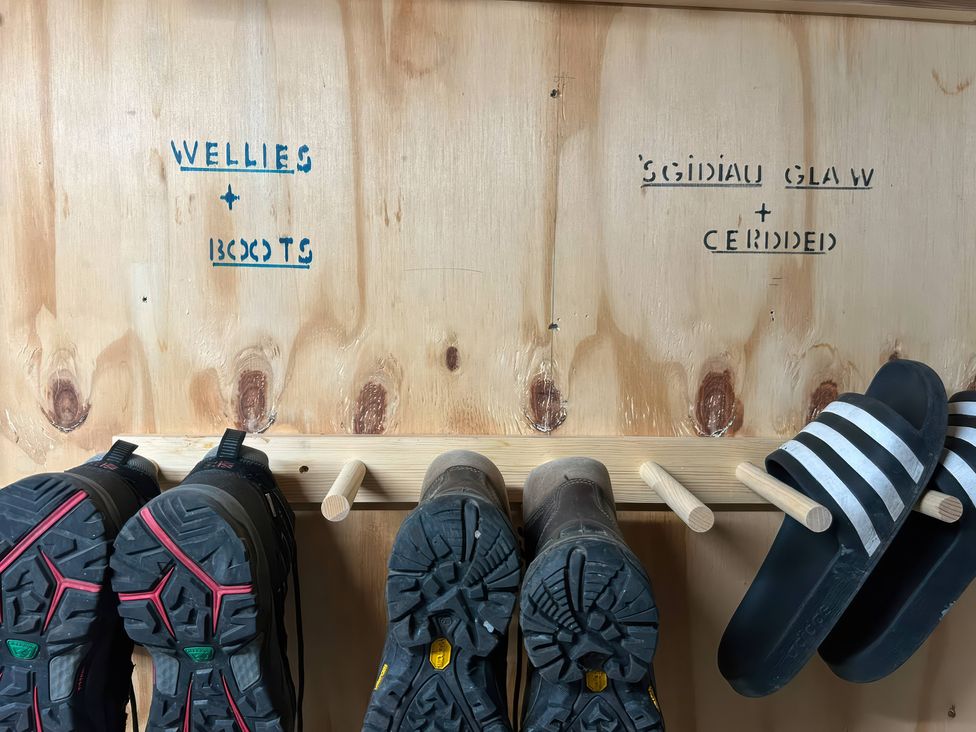 An entryway shoe rack with wellies and boots at Teifi Villa St Dogmaels