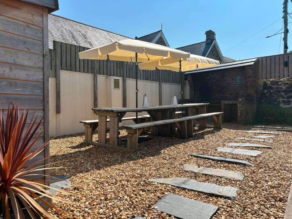 An outdoor area with a table and umbrella at Teifi Villa St Dogmaels
