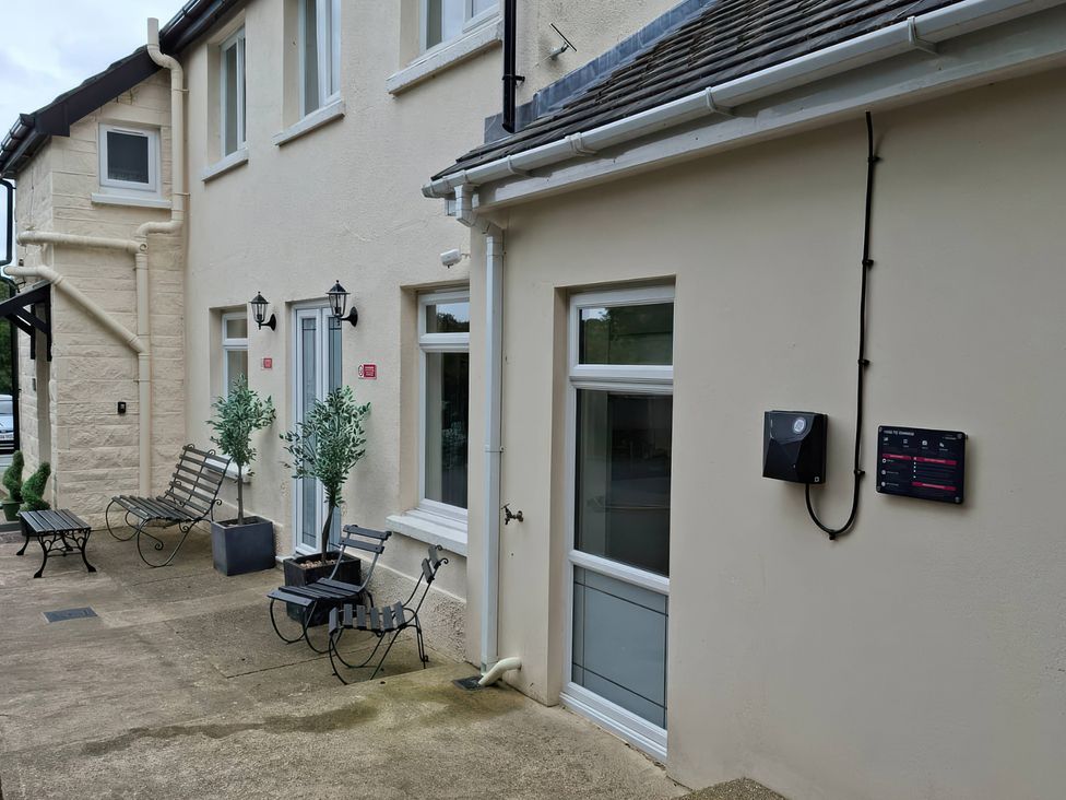 An outdoor area with benches and plants at Teifi Villa St Dogmaels