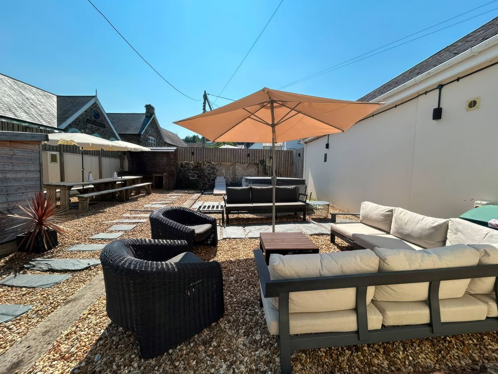 An outdoor seating area with a table and chairs at Teifi Villa St Dogmaels