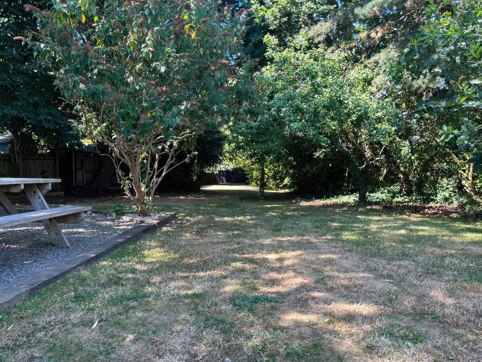 A garden with a table and trees at Teifi Villa in St Dogmaels