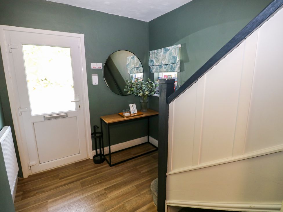 A hallway with a console table and mirror at Teifi Villa in St Dogmaels