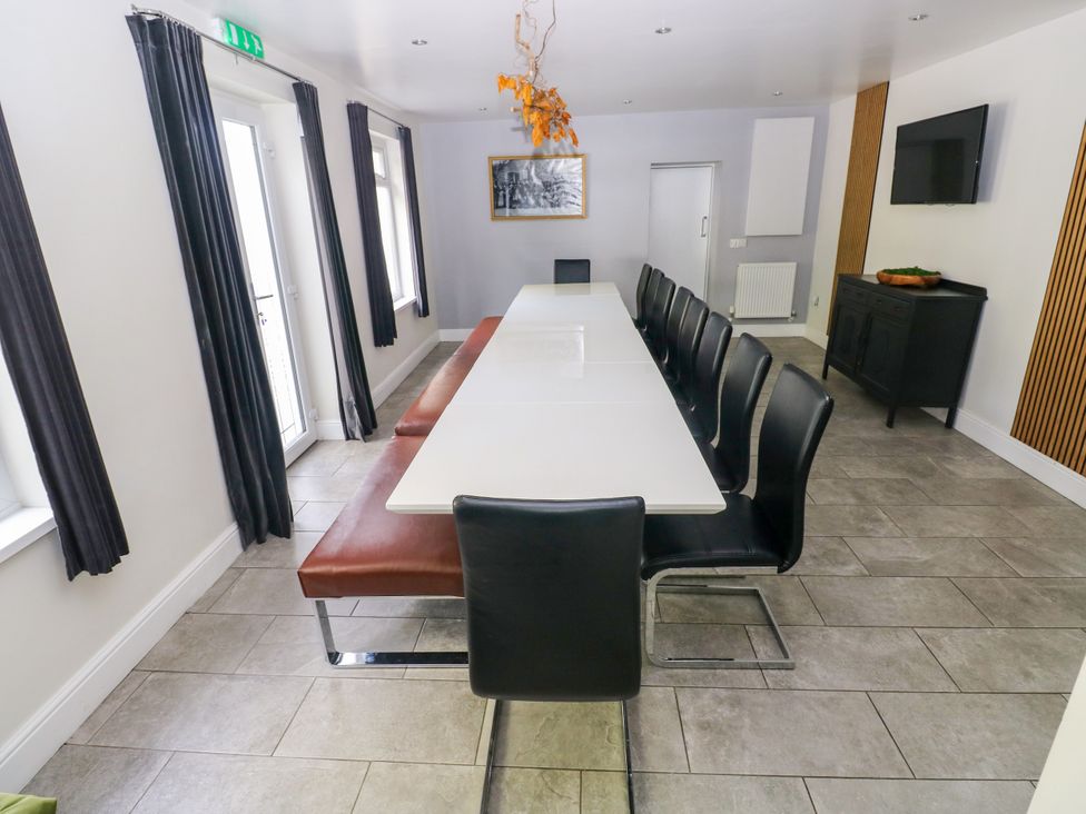 A dining room with a large table and chairs at Teifi Villa in St Dogmaels