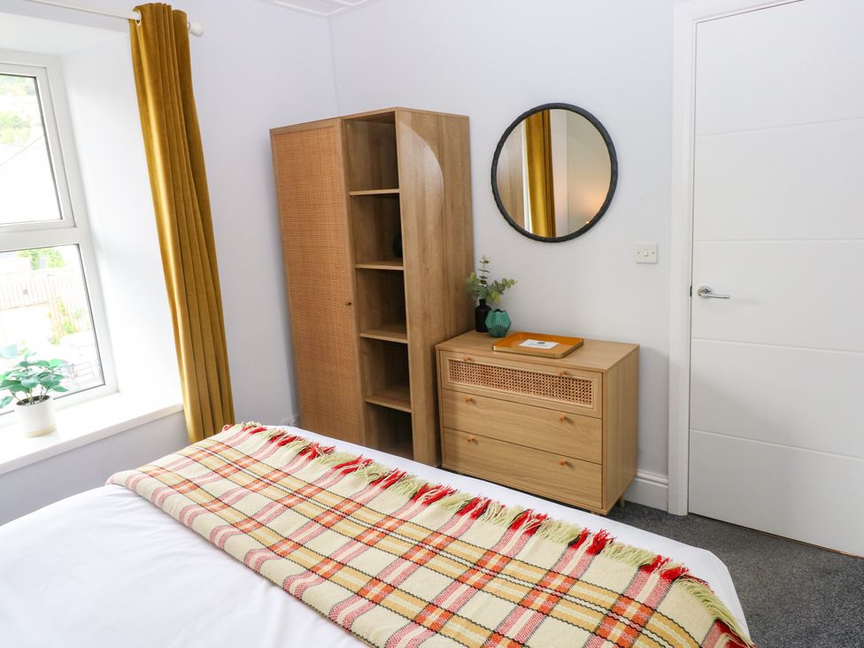 A bedroom with a bed and shelf unit at Teifi Villa in St Dogmaels