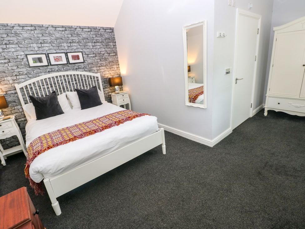 A bedroom with a bed and wardrobe at Teifi Villa in St Dogmaels