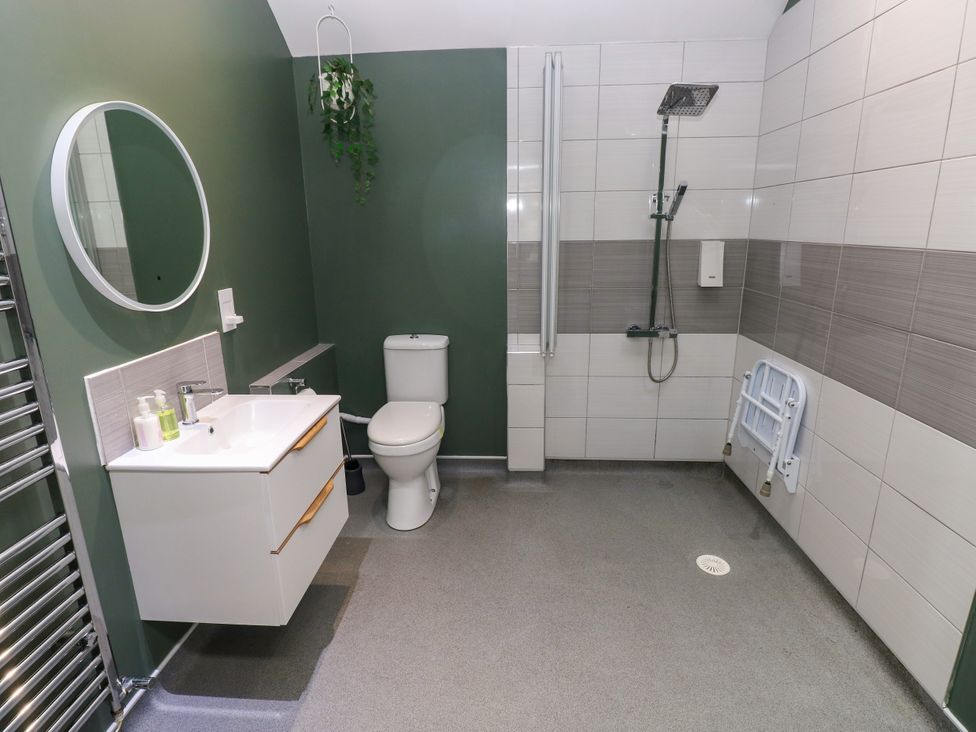 A bathroom with a shower, sink, and toilet at Teifi Villa St Dogmaels