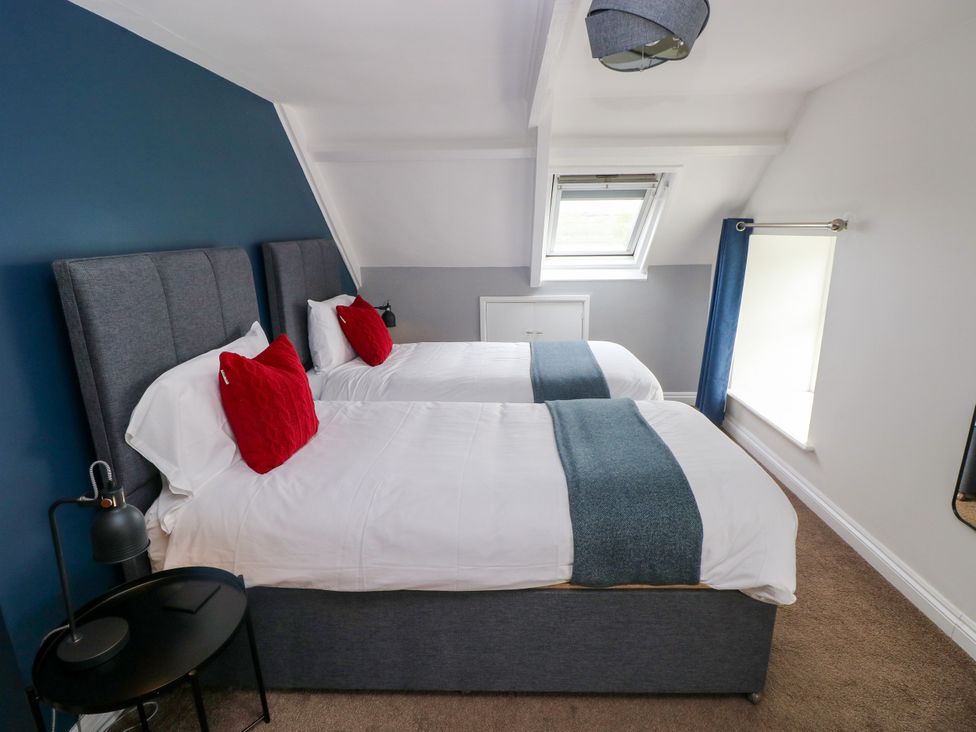 A bedroom with two beds and a window at Teifi Villa St Dogmaels