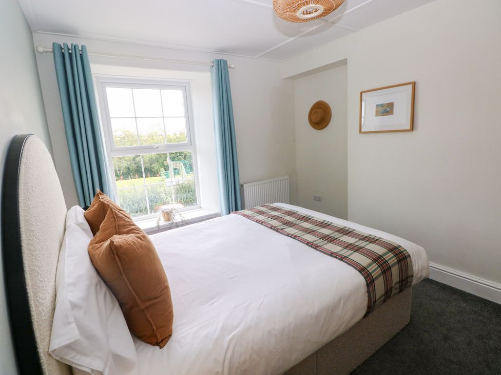 A bedroom with a bed and window at Teifi Villa in St Dogmaels