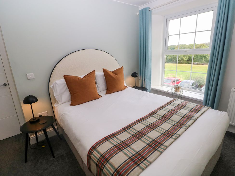 A bedroom with a bed and lamp at Teifi Villa in St Dogmaels