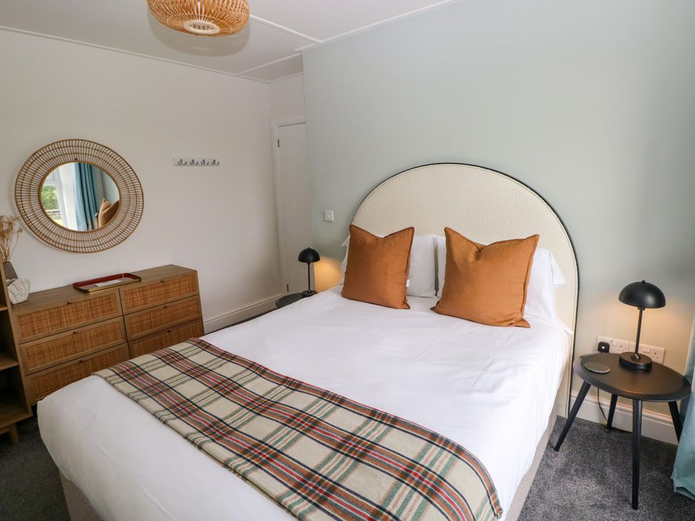 A bedroom with a bed and decorative items at Teifi Villa St Dogmaels