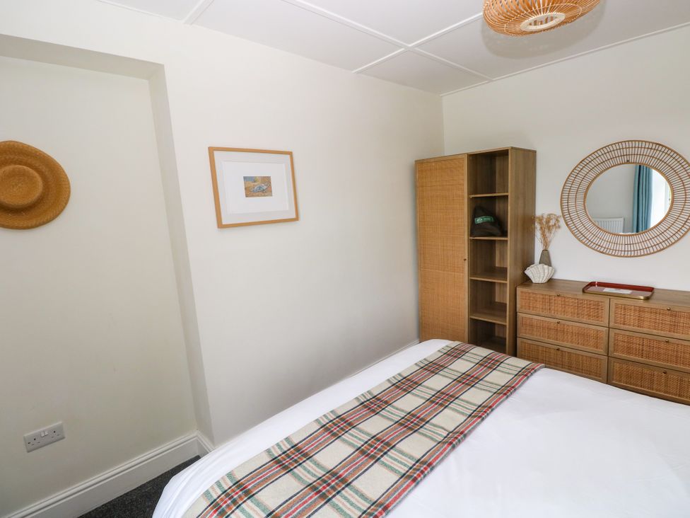 A bedroom with a bed and storage furniture at Teifi Villa in St Dogmaels
