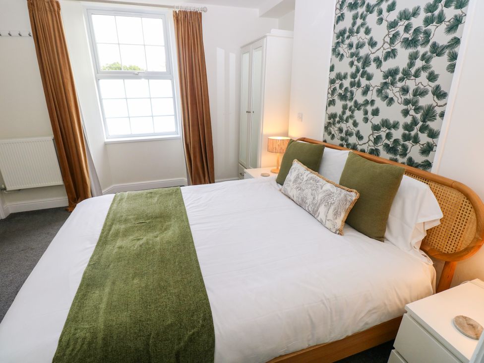 A bedroom with a bed and curtains at Teifi Villa in St Dogmaels