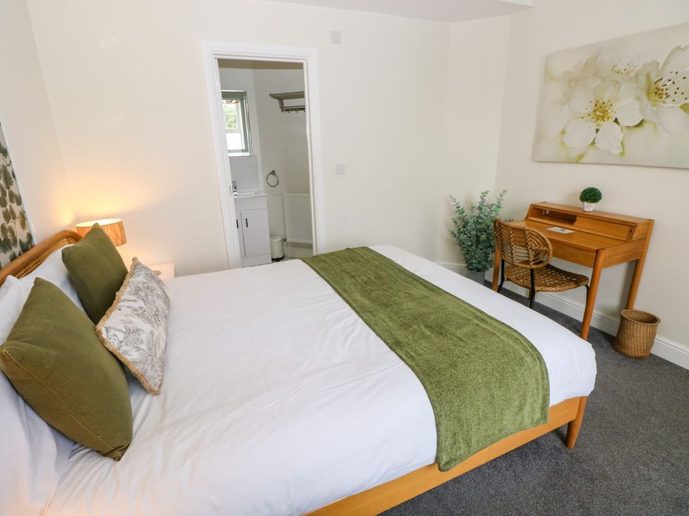 A bedroom with a bed and a desk at Teifi Villa St Dogmaels