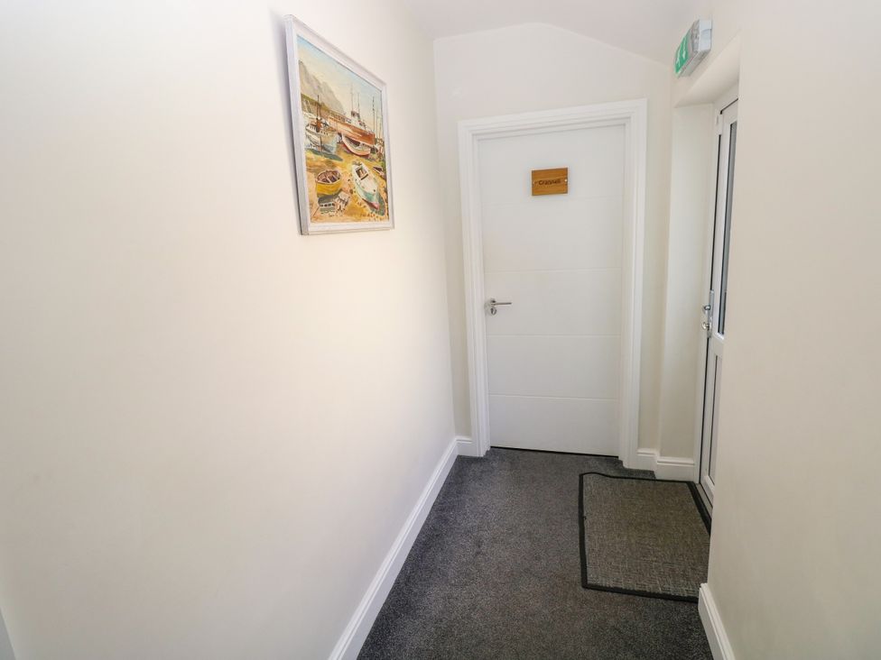 A hallway with a painting and a door at Teifi Villa in St Dogmaels