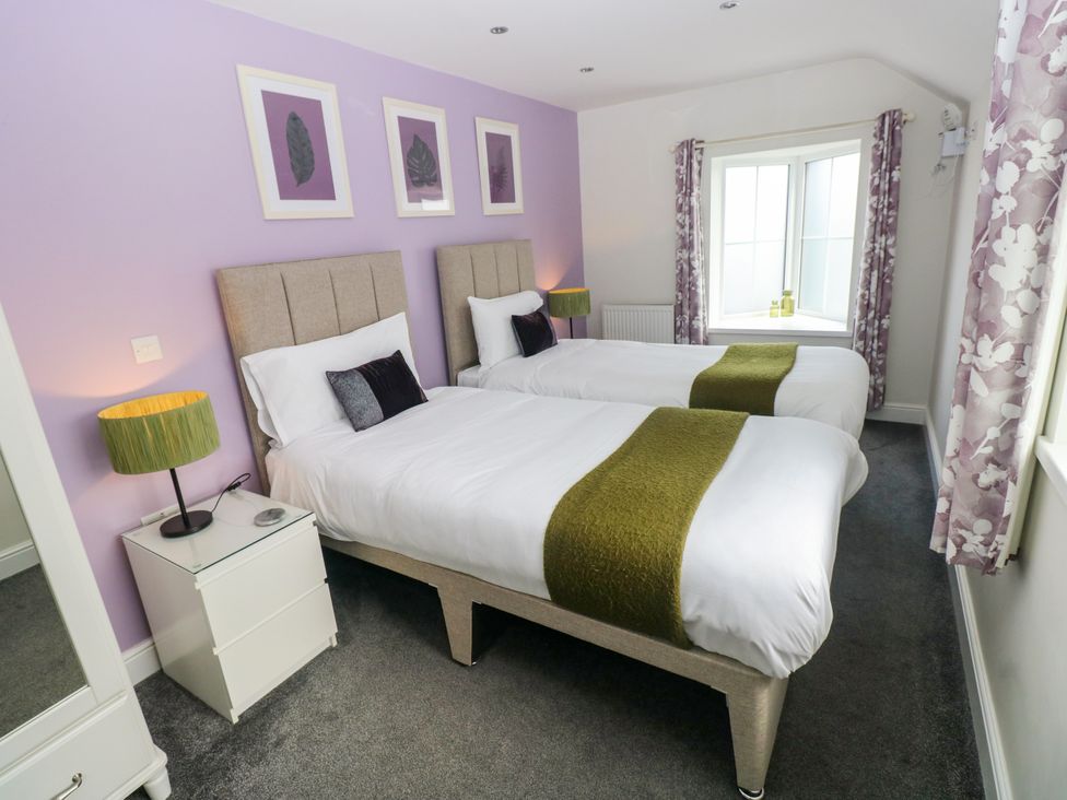 A bedroom with two beds and a window at Teifi Villa in St Dogmaels