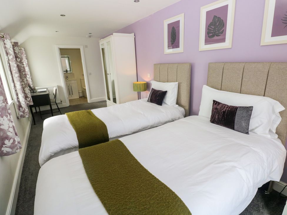 A bedroom with two single beds and a wardrobe at Teifi Villa in St Dogmaels