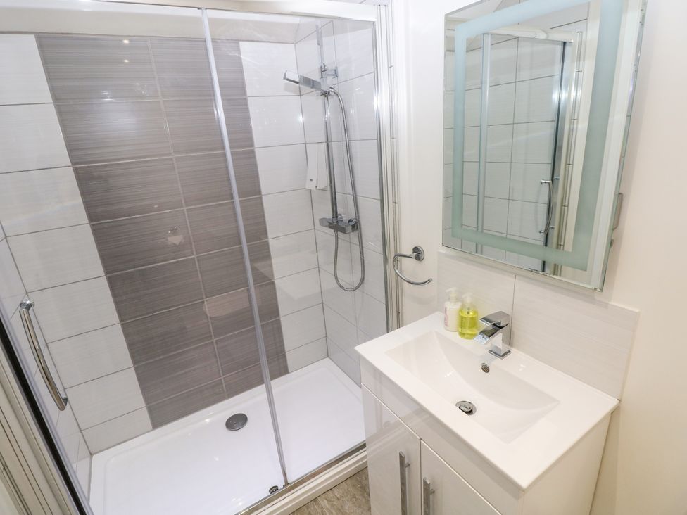 A bathroom with a shower and sink at Teifi Villa St Dogmaels