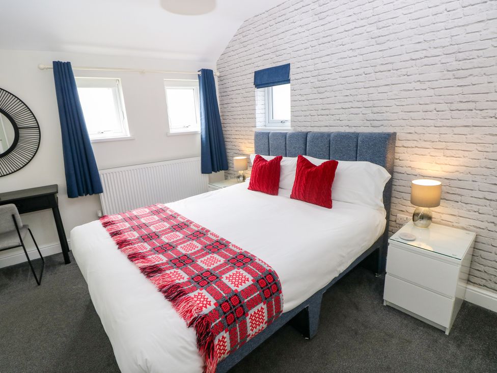 A bedroom with a bed and desk at Teifi Villa in St Dogmaels