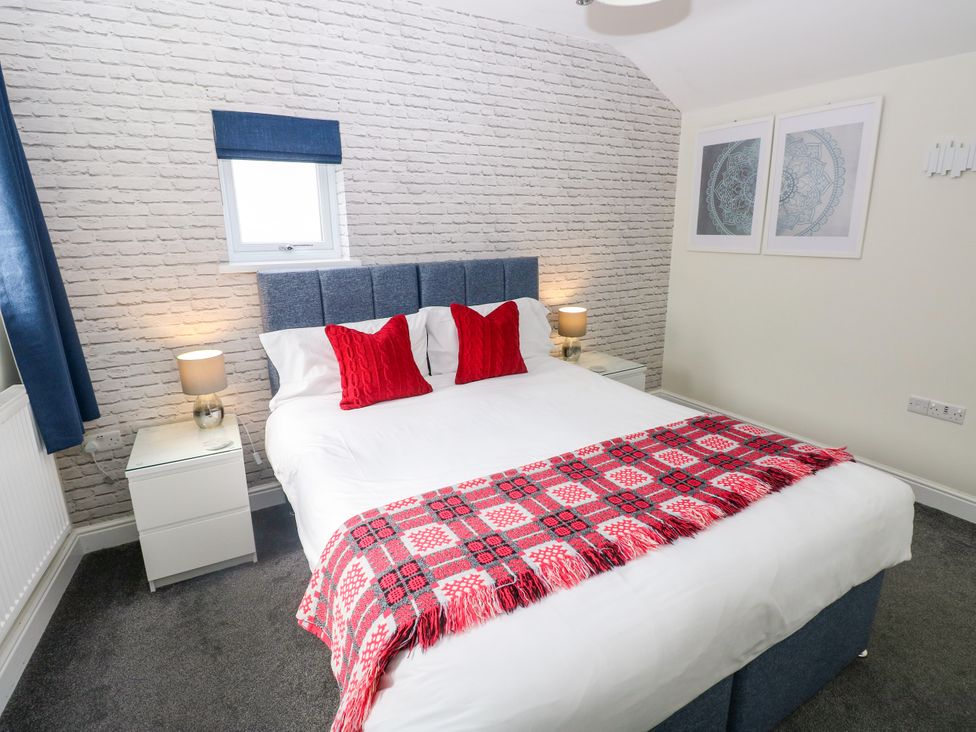 A bedroom with a bed and bedside tables at Teifi Villa in St Dogmaels