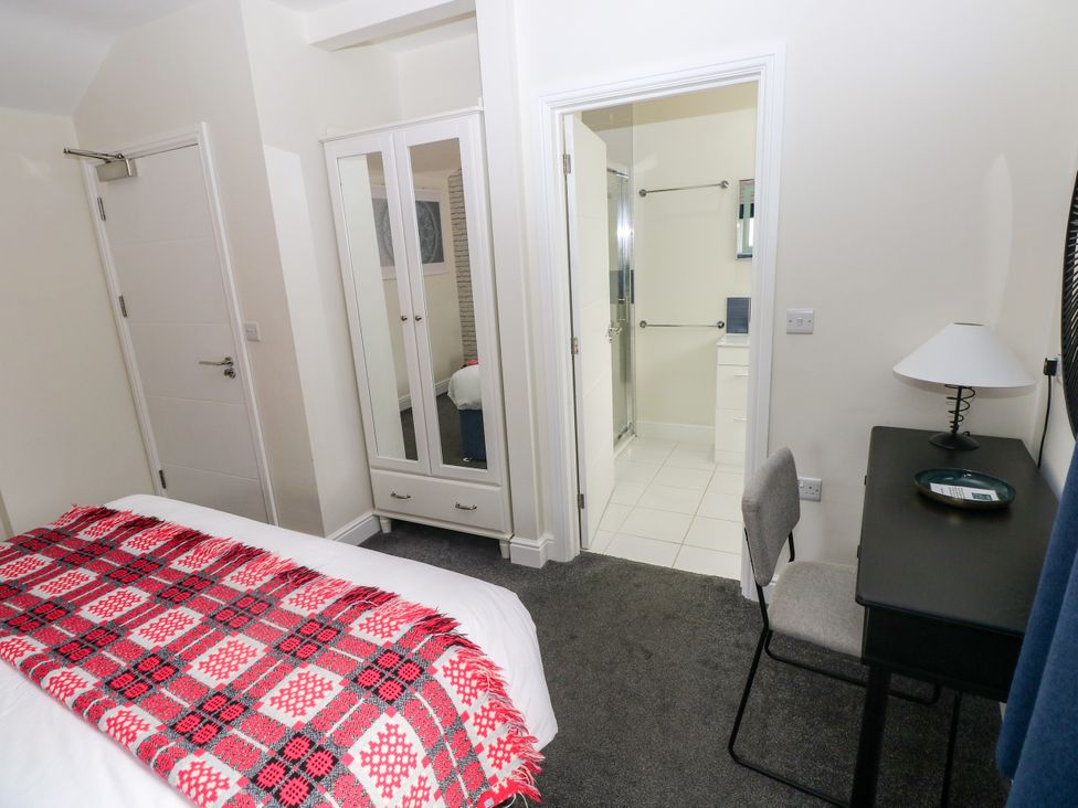 A bedroom with a bed and wardrobe at Teifi Villa in St Dogmaels