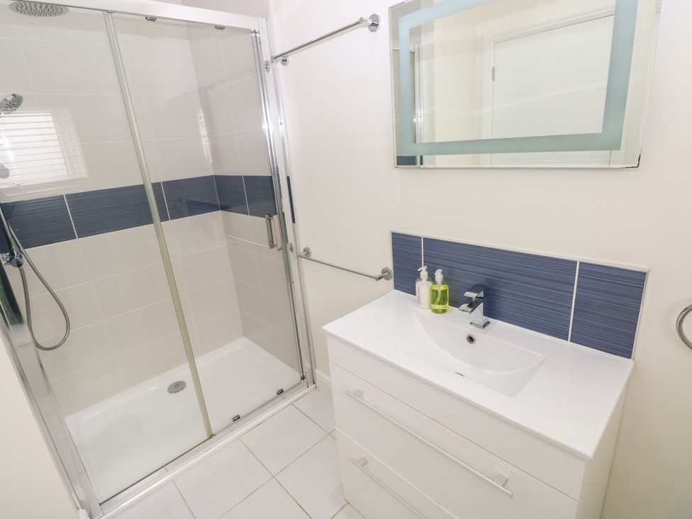 A bathroom with a shower and sink at Teifi Villa St Dogmaels