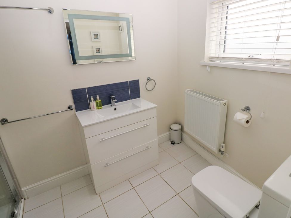 A bathroom with a sink and mirror at Teifi Villa in St Dogmaels