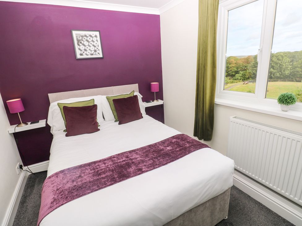 A bedroom with a bed and lamps at Teifi Villa in St Dogmaels
