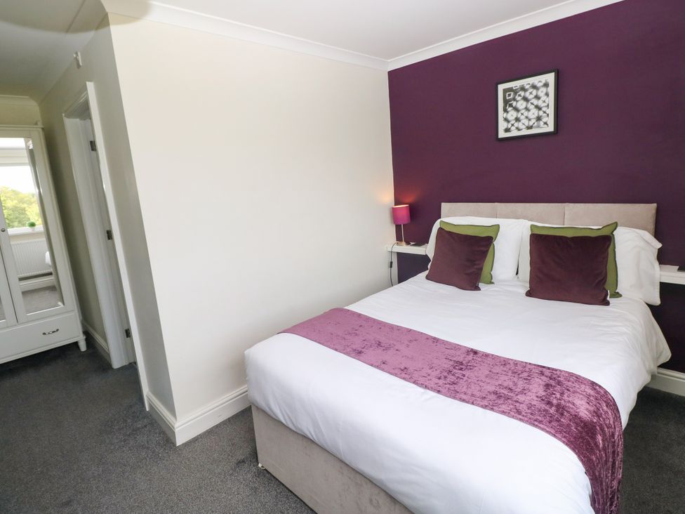 A bedroom with a bed and a lamp at Teifi Villa St Dogmaels