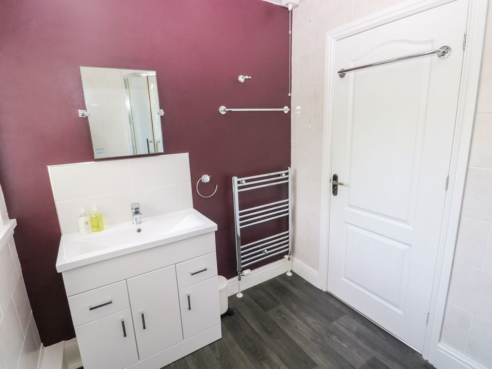 A bathroom with a sink and mirror at Teifi Villa in St Dogmaels