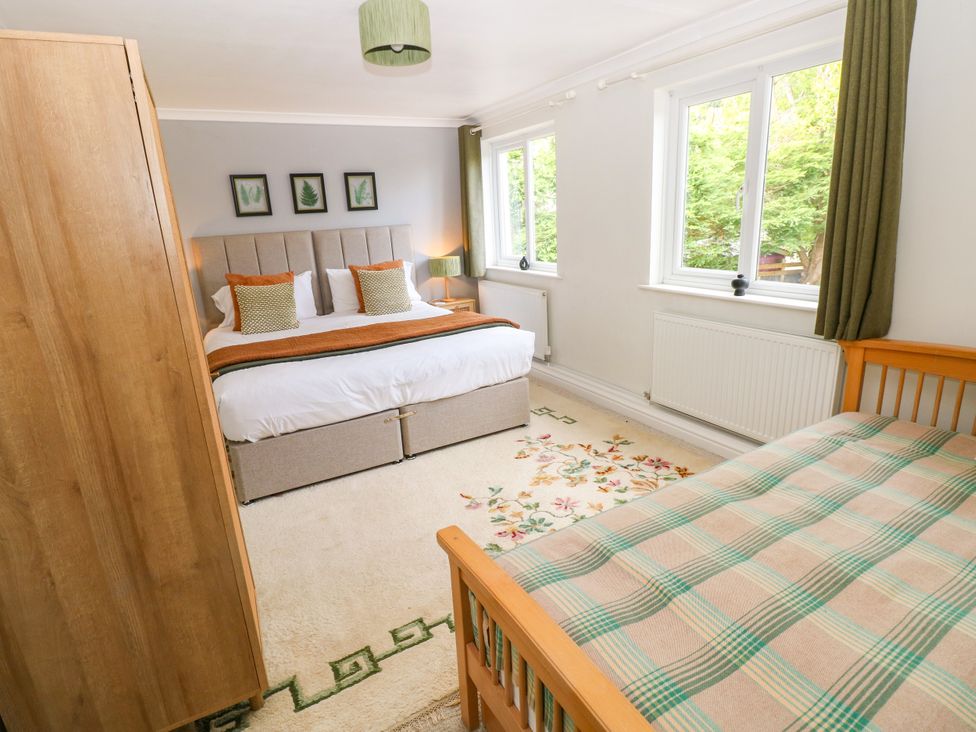 A bedroom with a bed and wardrobe at Teifi Villa in St Dogmaels