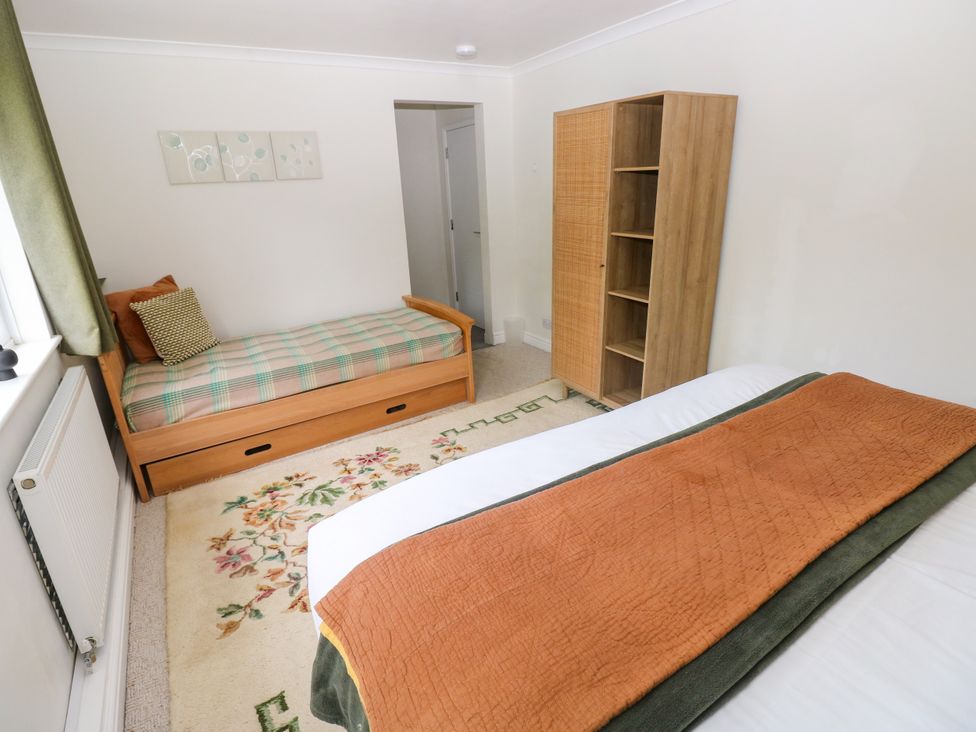 A bedroom with a bed and shelf at Teifi Villa in St Dogmaels