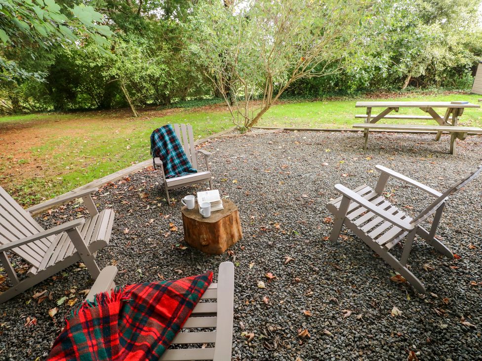 A garden with outdoor seating and a table at Teifi Villa St Dogmaels