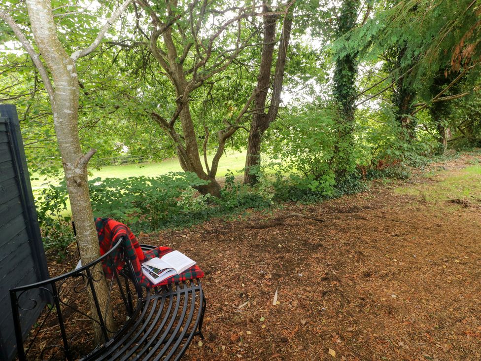 A garden area with a bench and a book at Teifi Villa, St Dogmaels