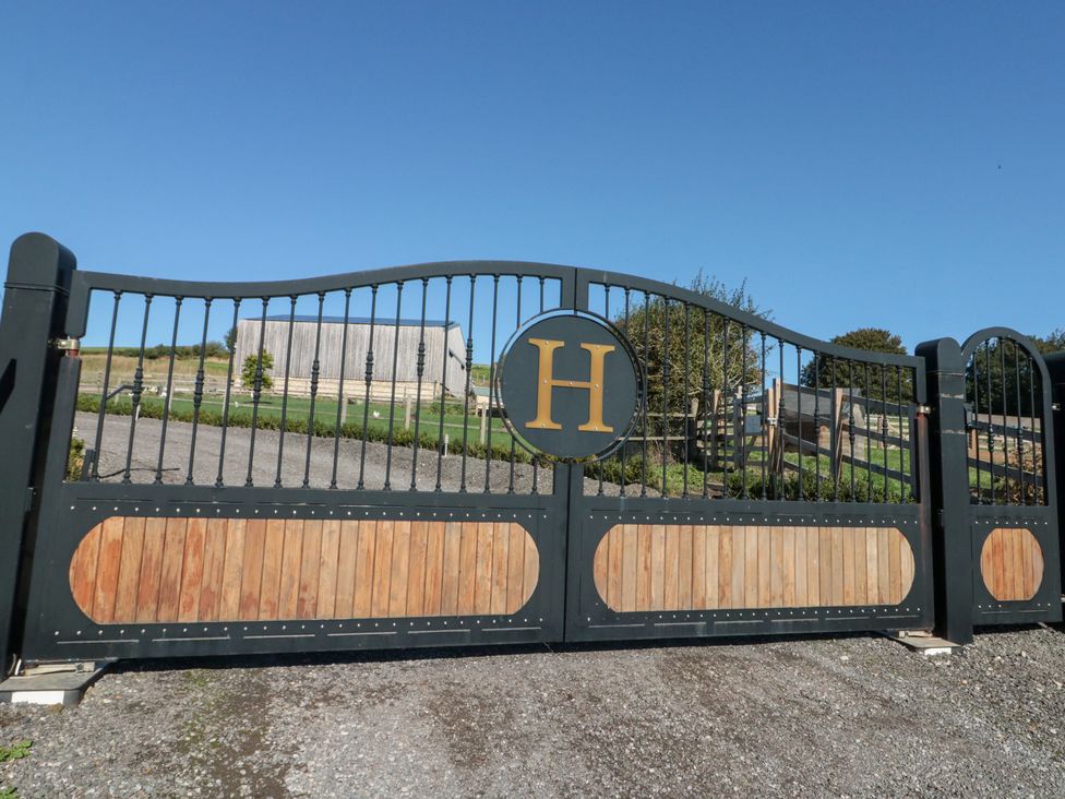 A gate with emblem and a barn in the background at Foxes Den in Allerston near Thornton Dale