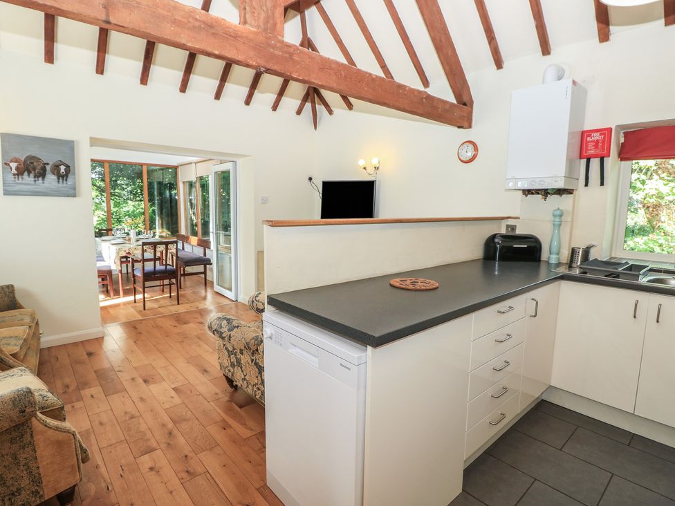 A kitchen with appliances and seating area at Byre Cottage 4 in Sullington near Storrington