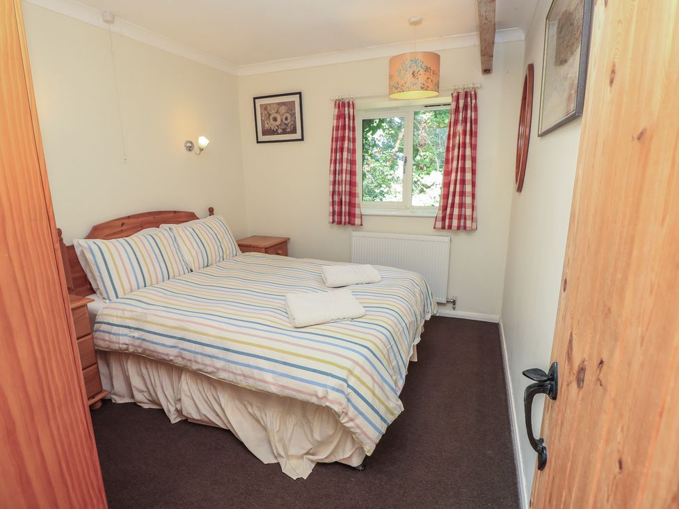 A bedroom with a bed and nightstand at Byre Cottage 4, Sullington near Storrington