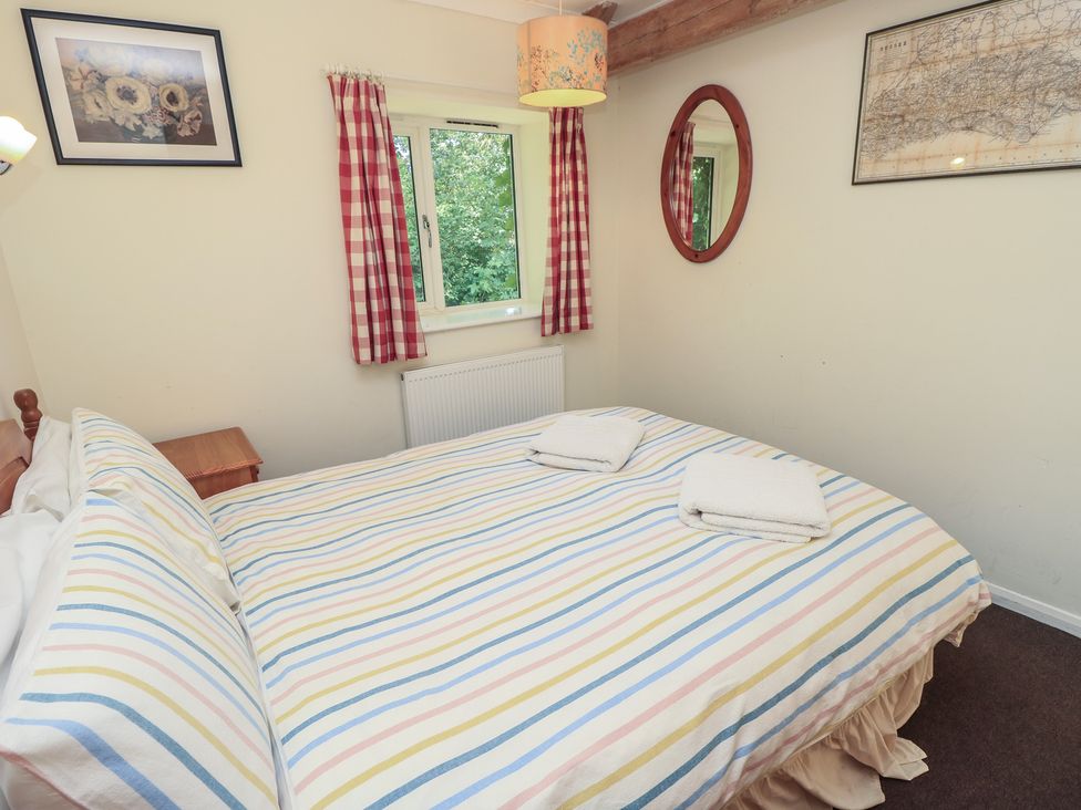 A bedroom with a bed and window at Byre Cottage 4 Sullington near Storrington