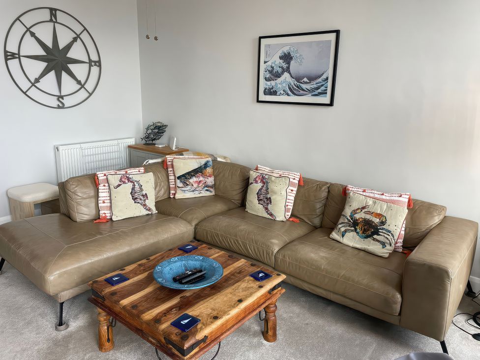 A living room with a sofa and coffee table at Sunrise Apartment in Weymouth
