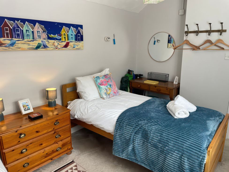 A bedroom with a bed, nightstand and drawer at Sunrise Apartment in Weymouth