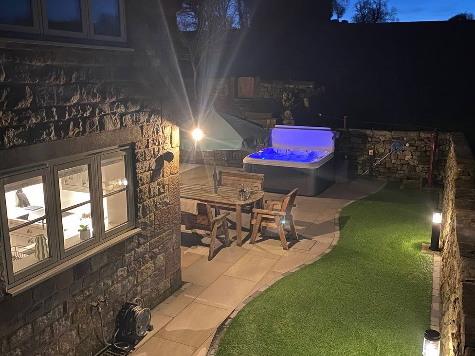 A garden with a hot tub and dining area at Small Lane Cottage Blackwood Hill near Endon